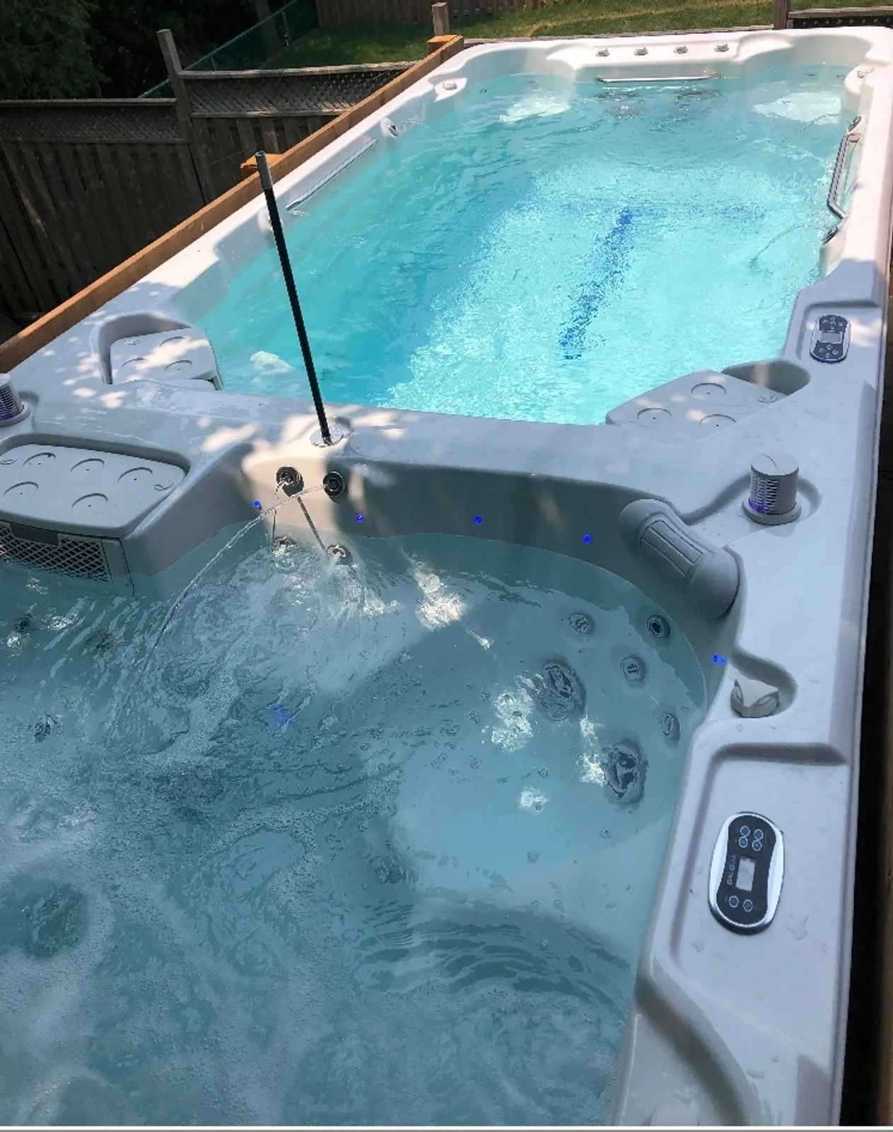 The 20ft Dual Santorini swim spa installed in a backyard, showing the swim lane and the hot tub end